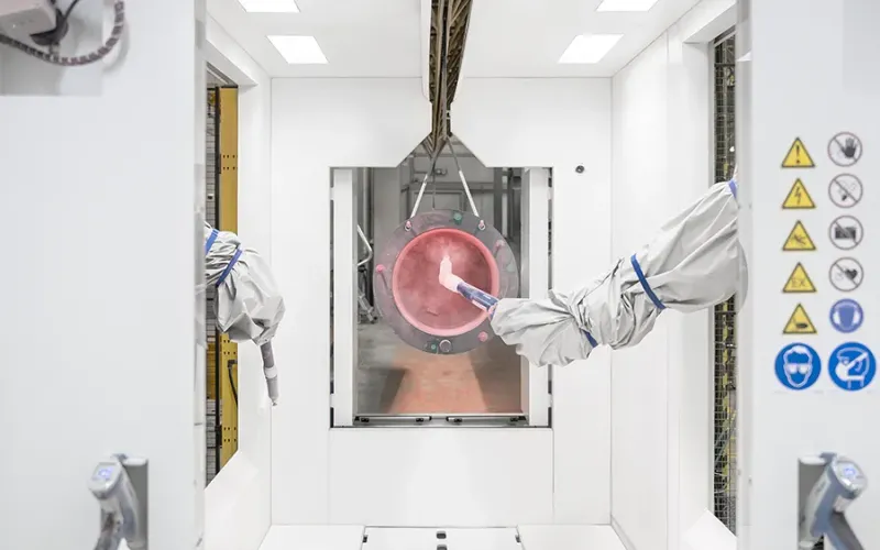 Robotic arms powder coating a metal part