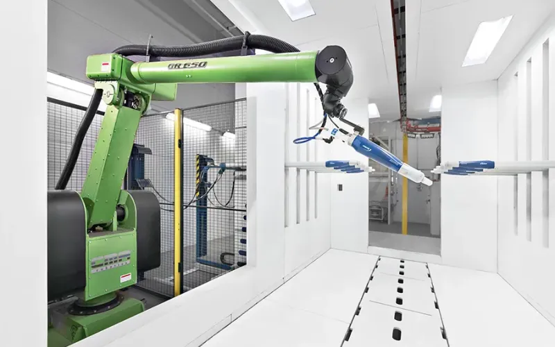Green robotic arm in a coating booth