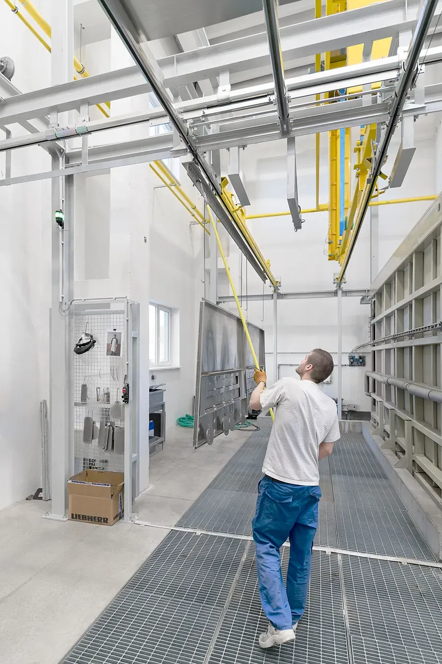 Worker pushing metal parts on conveyor