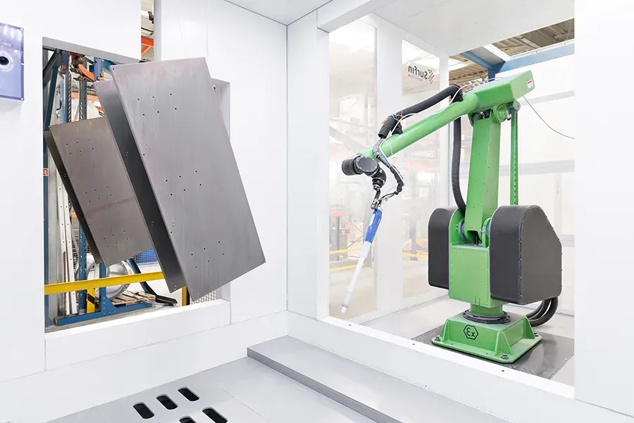 Metal parts on a conveyor with a coating robot arm