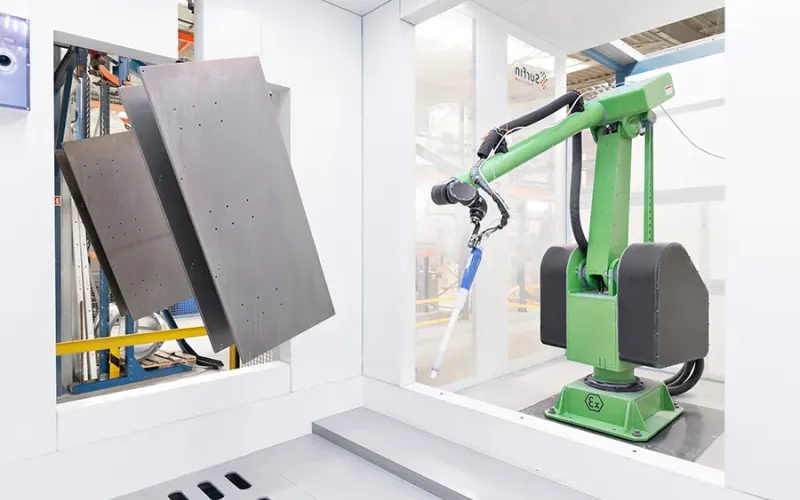 Metal parts on conveyor with coating robot arm