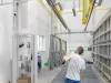 Worker pushing metal parts on conveyor