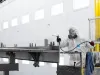 Worker manually coating wagon