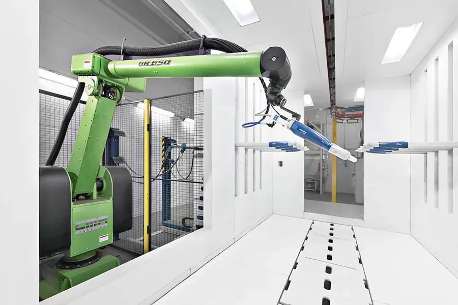 Green robotic arm in a coating booth