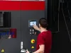 Technician operating carousel blasting machine