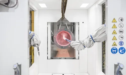 Robotic arms powder coating a metal part